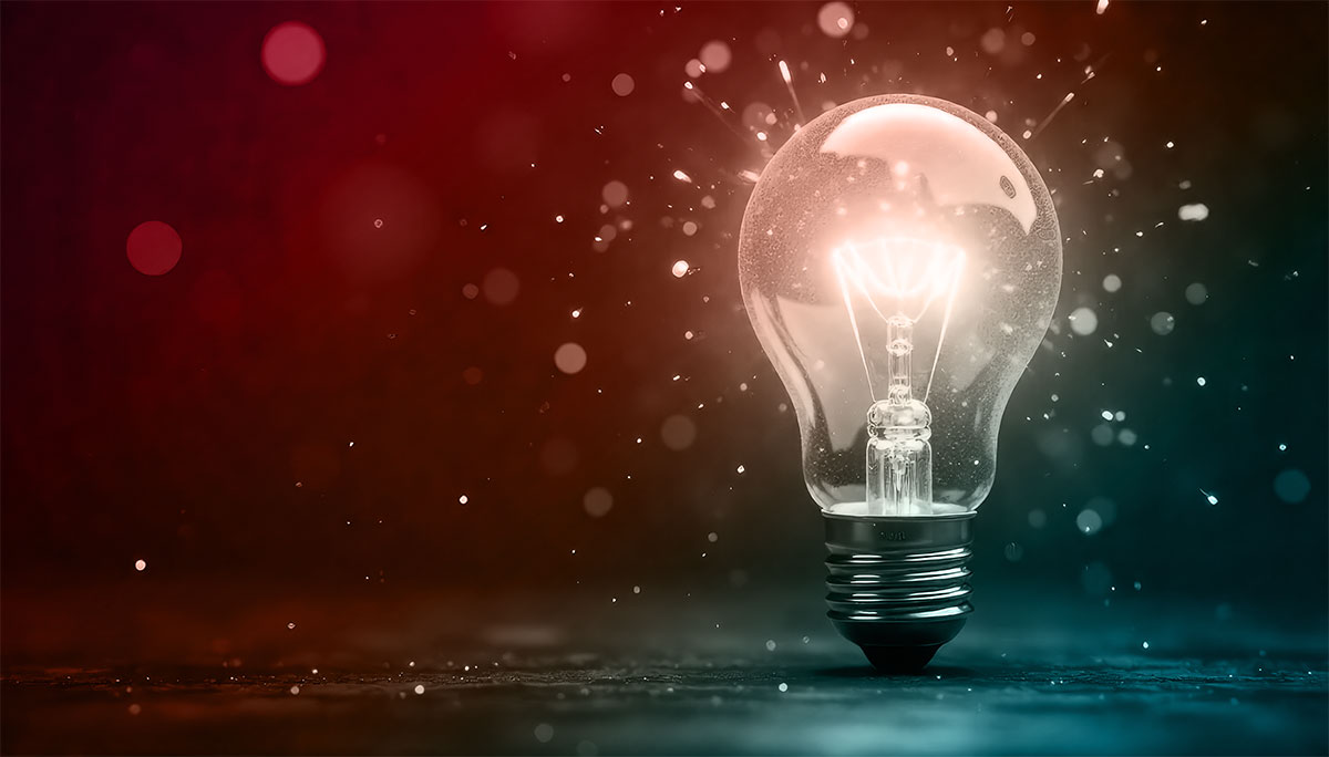 A glowing light bulb surrounded by sparkles and a gradient background of red and blue tones.
